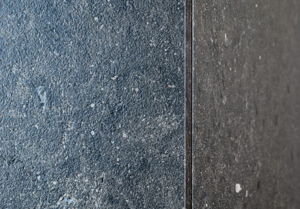 Die Wohnküche im Penthouse H. wurde in schwarzem Kalkstein (Pierre Bleu Pec) mit grober Oberfläche ausgeführt. Die rohe Haptik des handgeschliffenen Steins setzt auf Natürlichkeit auf der Fläche und an der Wand.