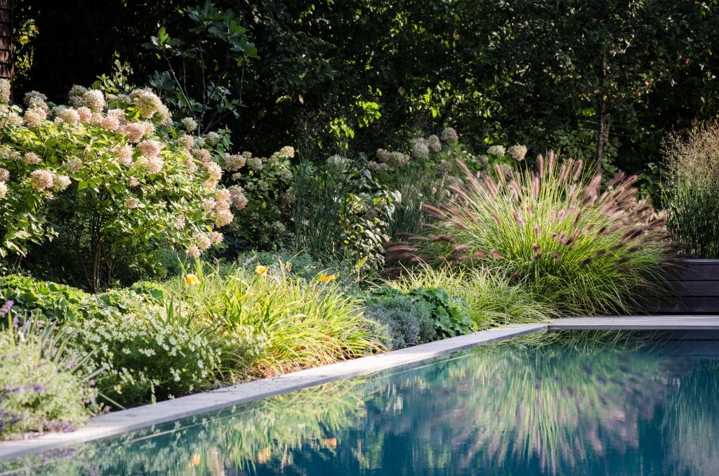 Die Villa am Waldrand von Atelier Claus Radler setzt auf zeitlose und dauerhafte Materialien. Neben dem Pool, den Steinmauern, den Terrassen und der Wegeführung in der sehr natürlich gewachsenen Gartengestaltung von Clemens Lutz kommt im Wohnzimmer ein schöner türkischer Marmor von Breitwieser zum Einsatz