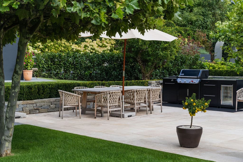 Terrasse und Poolbereich sind mit feinstem San Luca verkleidet. Der warm anmutende Kalkstein aus Kalabrien legt sich mit ruhiger Selbstverständlichkeit in den großzügig angelegten Garten.